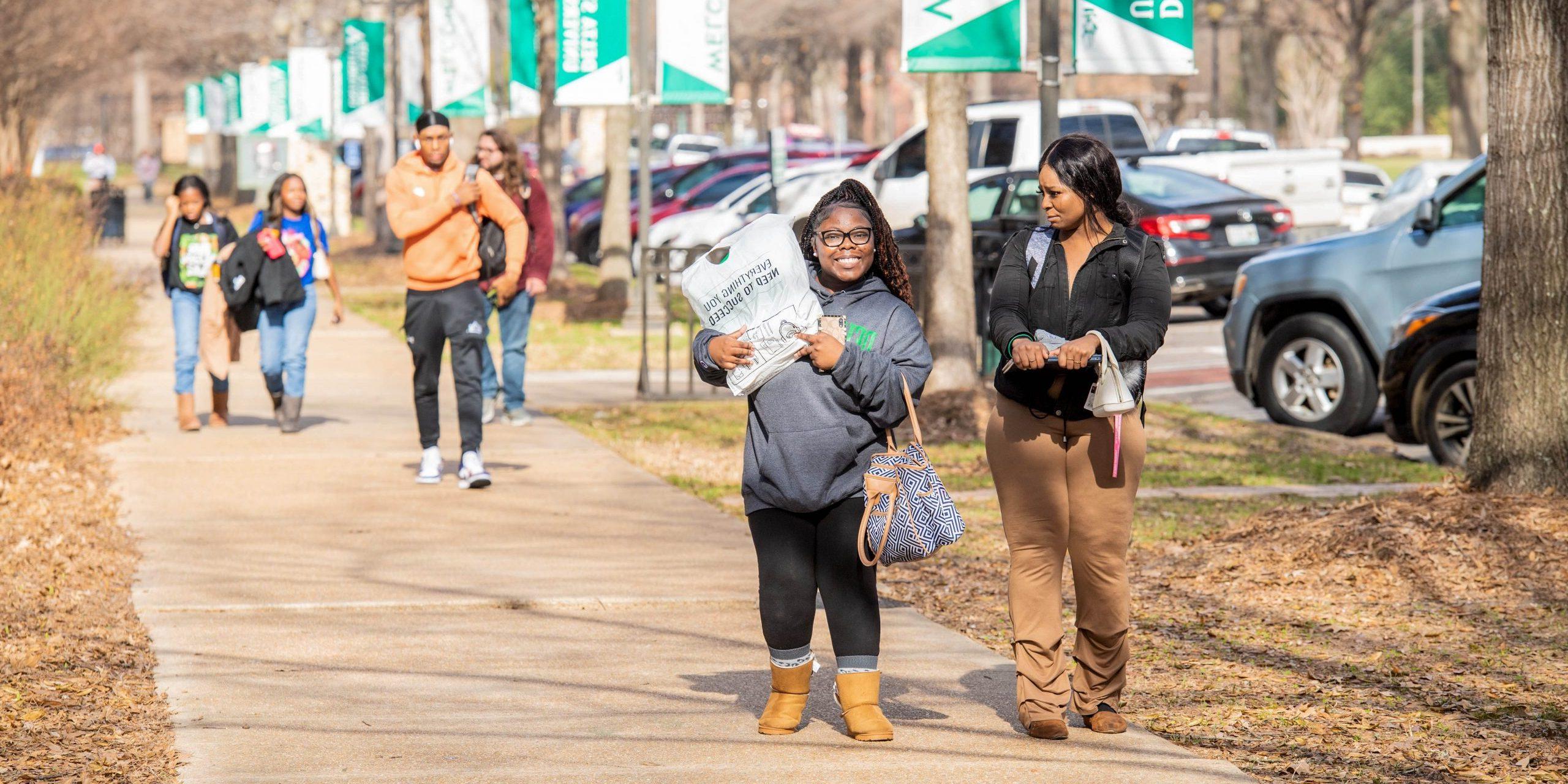 Freshmen students walking to call on the first day of school with books and backpacks.